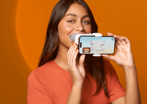 Mulher usando o scan dental para monitoramento remoto SouSmile