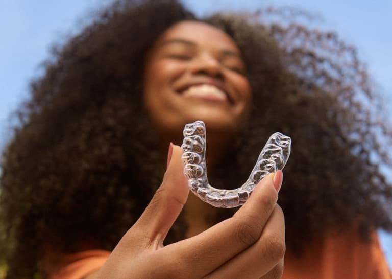 Mulher segurando o aparelho invisível SouSmile