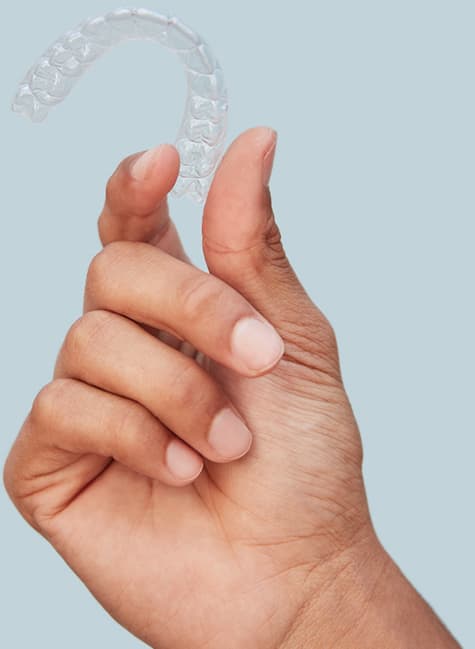 Uma mão segurando o aparelho invisível SouSmile