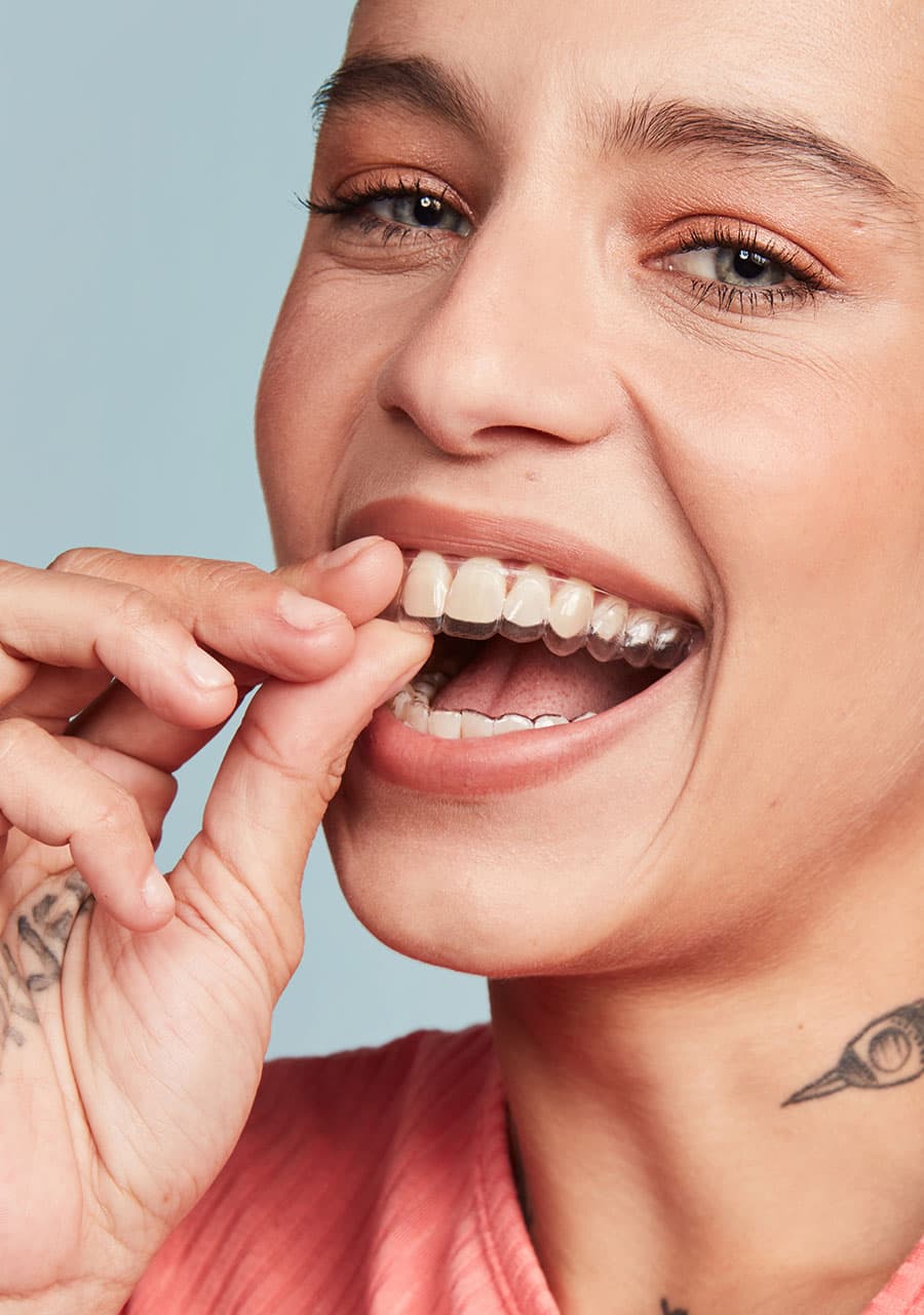 mulher sorrindo segurando o alinhador