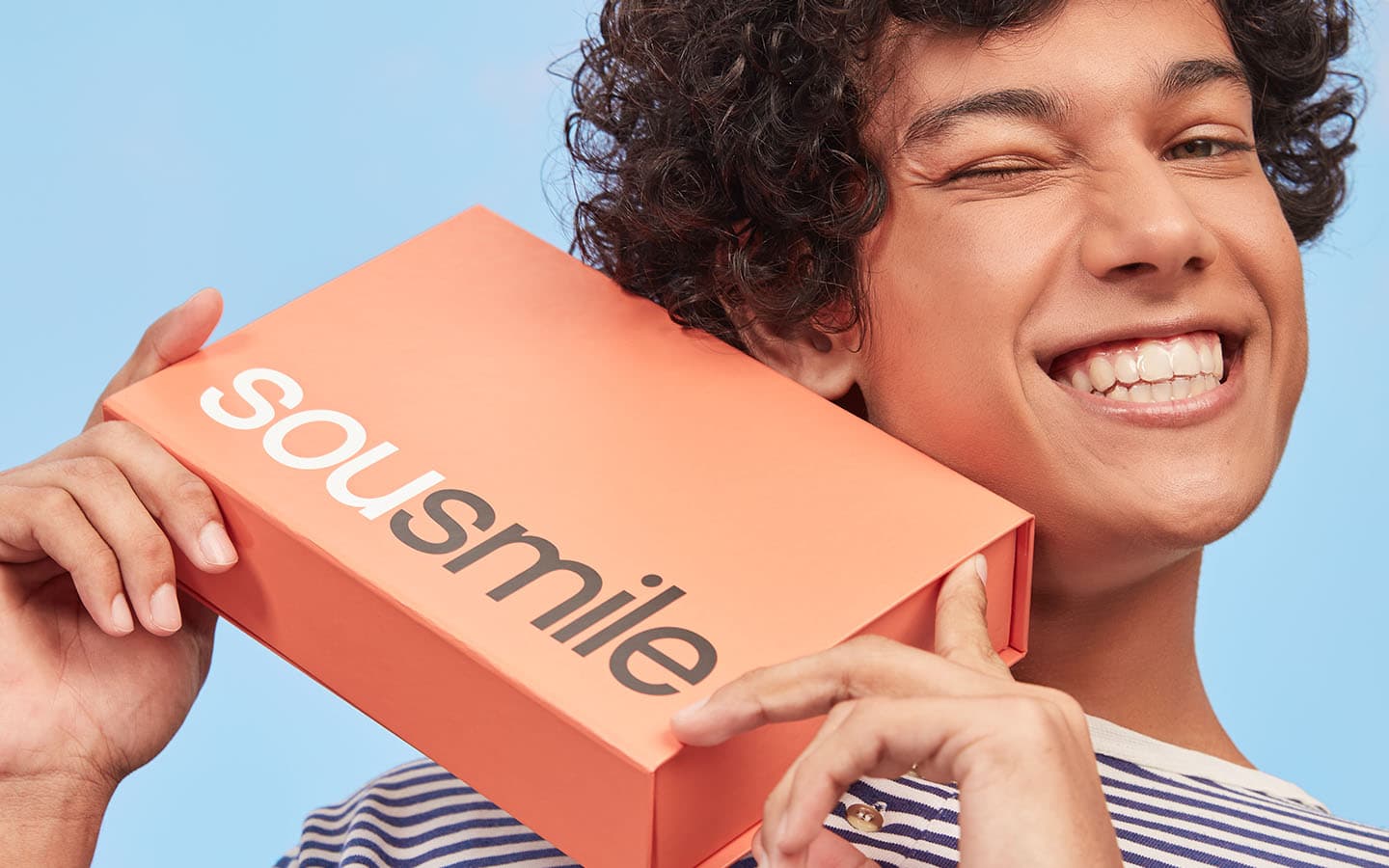 Homem segurando a caixa com o aparelho transparente SouSmile