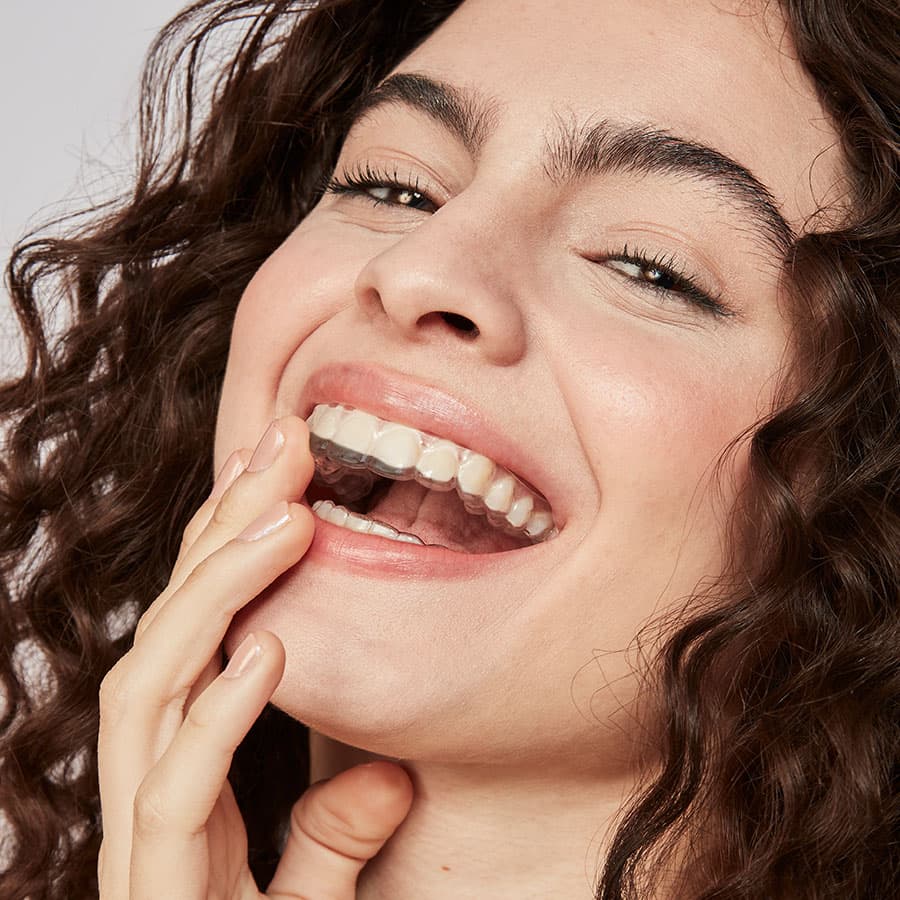 mulher sorrindo com uma das fases do aparelho transparente
