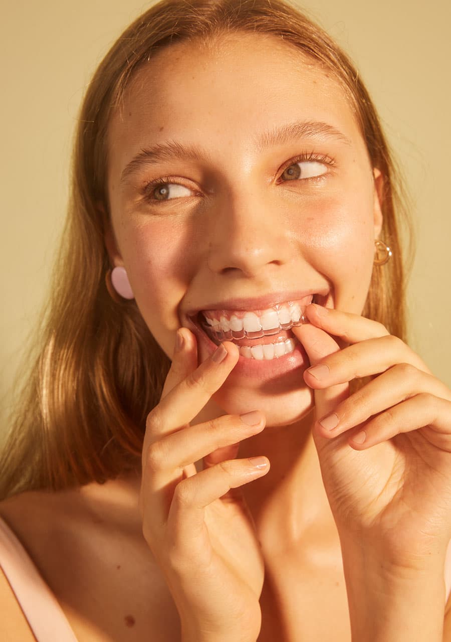 mulher sorrindo com aparelho transparente