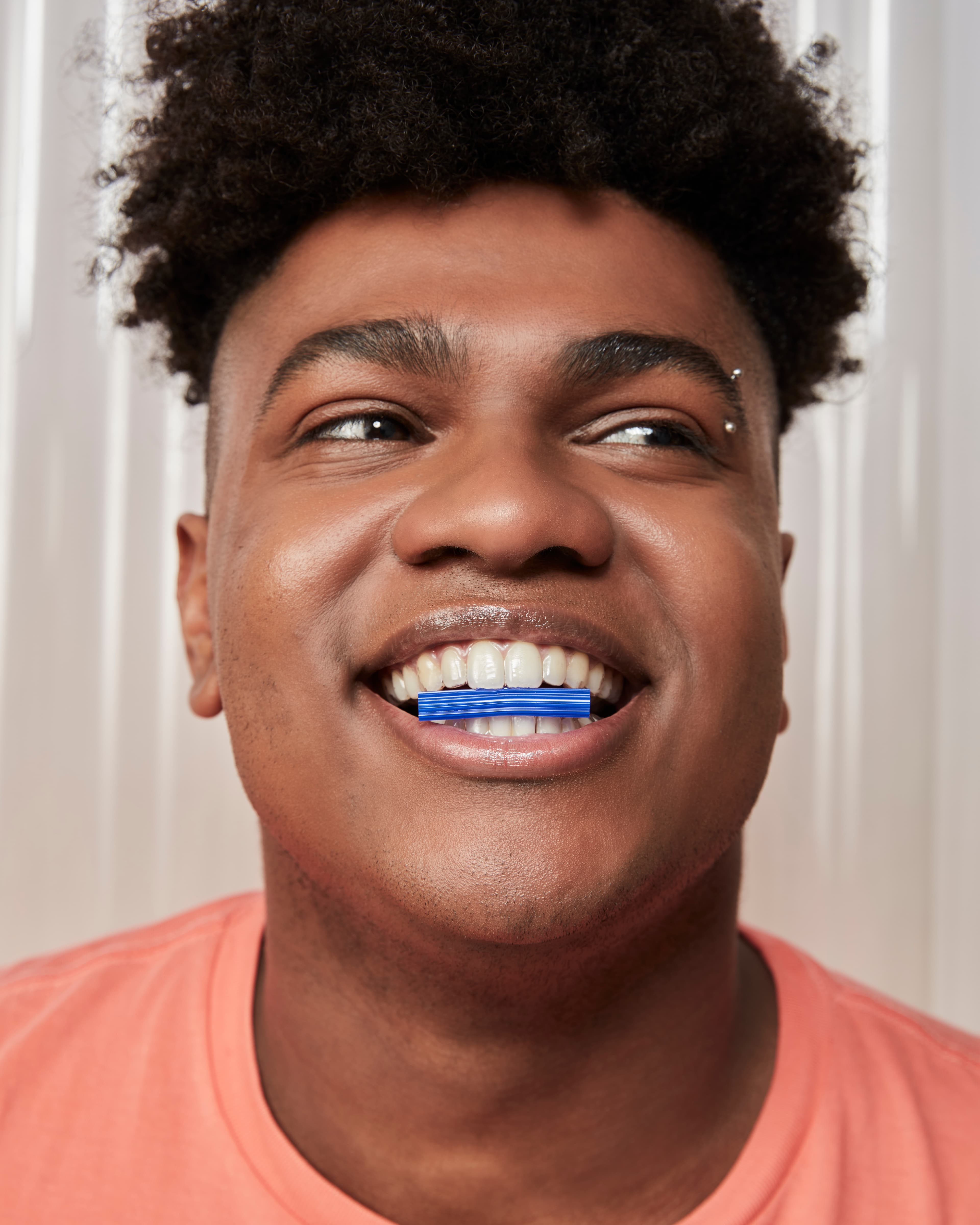 Jovem negro sorrindo com aparelho invisivel