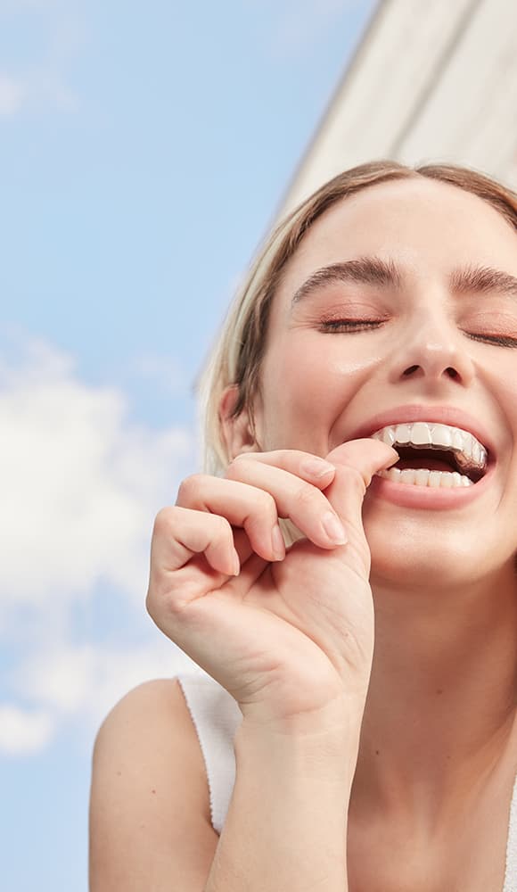 Mulher sorrindo com o aparelho transparente SouSmile
