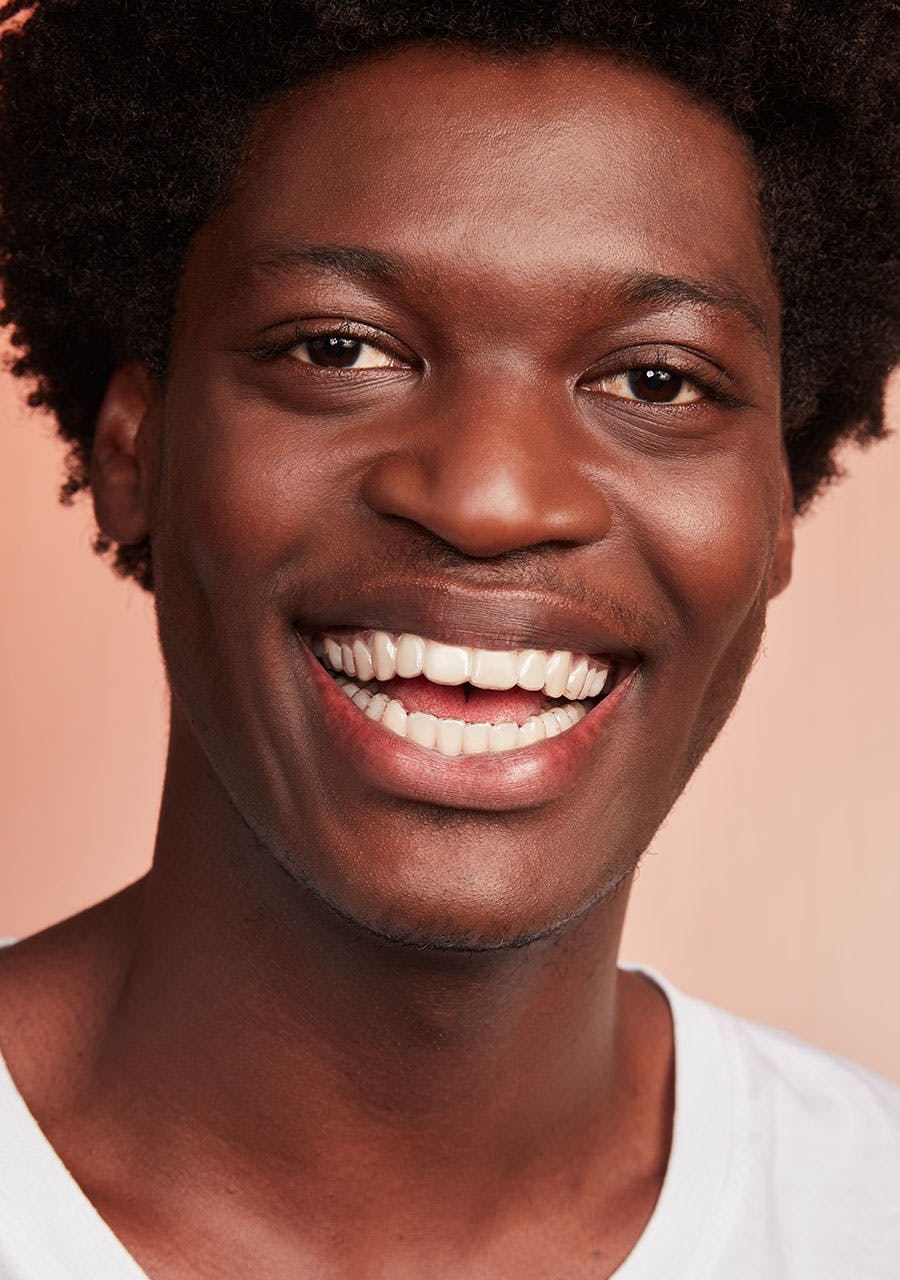 Jovem negro sorrindo com aparelho invisivel